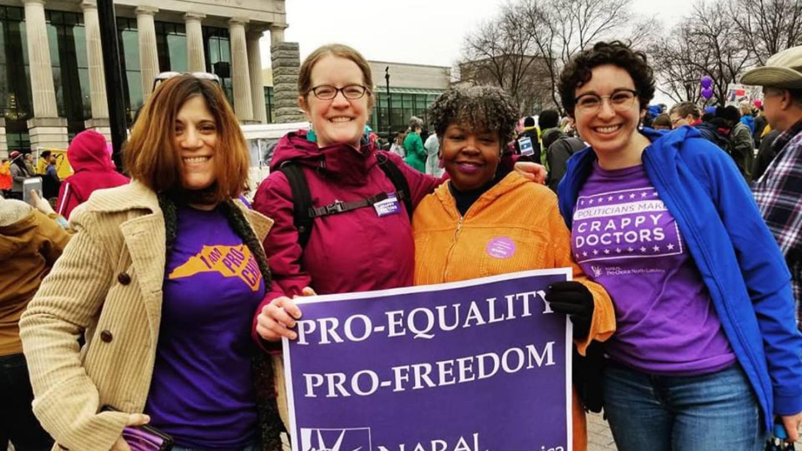 staff and volunteers hold 'pro-equality pro-freedom' sign